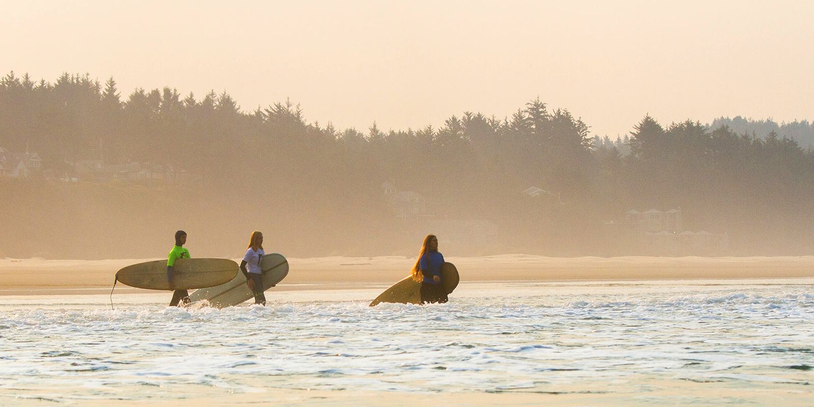 surfers walking into the surf