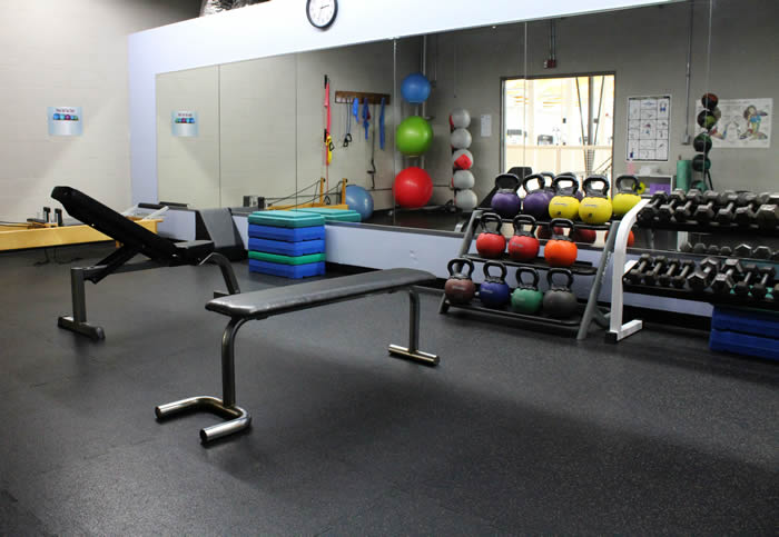 circuit training room with kettle balls, weights, and stretching area